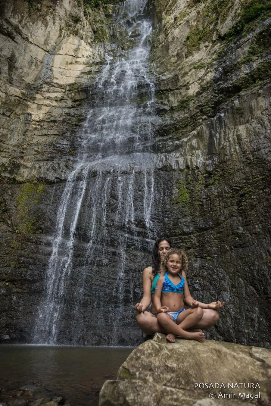 A woman and child sitting on a rock in the pool below El Salto del Nara